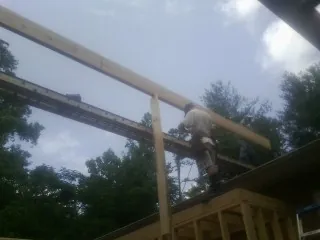 Carpenter setting a ridge beam over a new addition frame — Ice Dam Removal by Roofing Brothers in Potomac