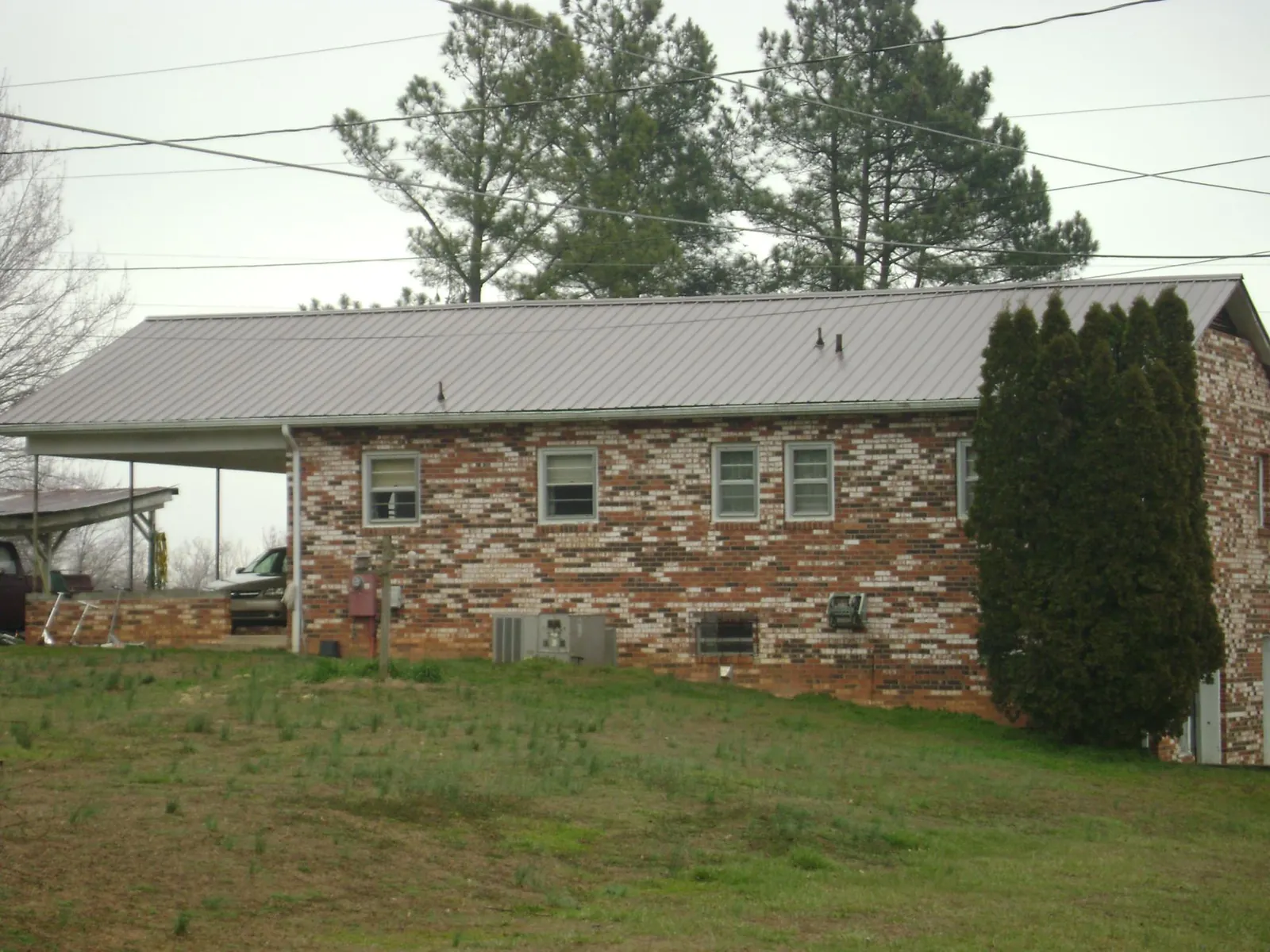 Gray metal roof on a brick split level home with a carport in Potomac