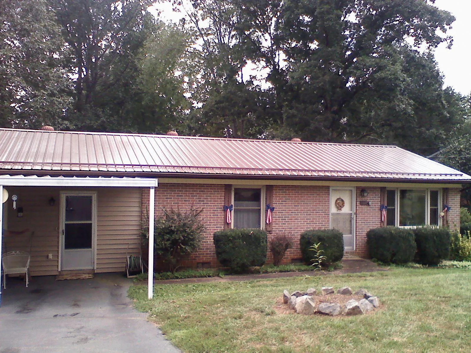Bronze metal roof and carport on a brick ranch home — Roof Repair work by our crew in Potomac